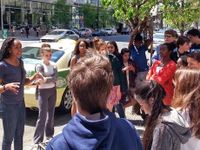 Class standing together on a street listening to instruction