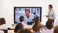 Students participate in a video call with a researcher.