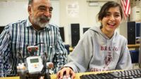 Teacher and student at the computer with her robot