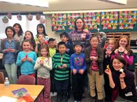 Teachers and students holding their origami creations