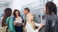 A diverse group of students converse at their lockers.