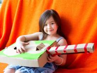 Young girl holding a cardboard guitar