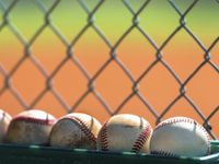 Photo of baseballs against a fence