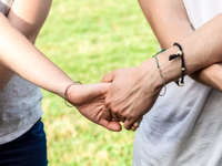 A photo of students with their wrists crossed, holding hands, in a group exercise.