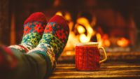 Photo of feet in socks propped up in front of a fire