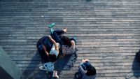 photo of a birds-eye-view of people sitting on a deck