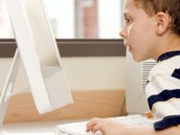 Young boy looking at a computer monitor