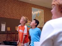 Two boys and an adult in the sidelines