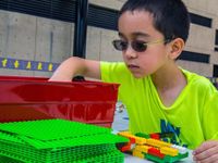 Boy wearing glasses building with legos