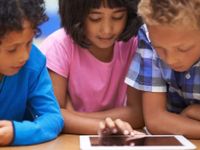 Three children around a tablet device