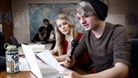 Boy and girl recording voice on laptop