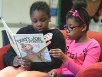 Two girls reading together