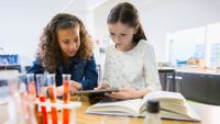 Two girls work together on a science project.