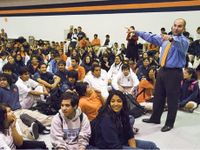 Animated principal, speaking to student body in gymnasium