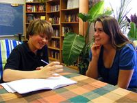 A photo of a middle school boy talking with his teacher.