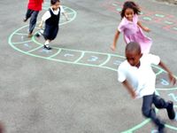 Kids running through a pathway drawn with chalk on the playground