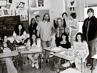 Teacher standing among his students in the classroom