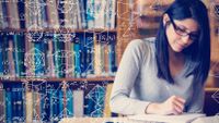 Photo of a female student studying math, with equations and geometric shapes drawn in white on the image