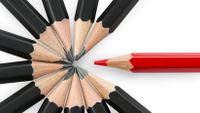 Photo of several black pencils and one red one.