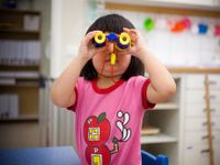 image of a young student using binoculars