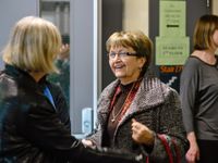 Two teachers are talking to each other out in the hallway.