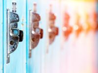 A closeup on 6 adjacent lockers. The first locker is clear and blue, each locker following gets more and more out of focus and shifts into reds and yellows, looking like a rainbow.