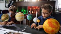 Two elementary aged boys make model of solar system 