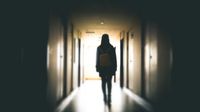 Teenage girl walking alone down hallway