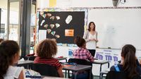 Elementary school teacher teaching students in classroom