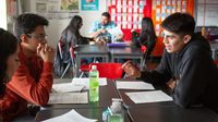 Small group of middle school students works together at their desks