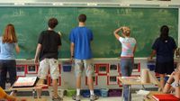 高中学生在学校的黑板上写西班牙语。