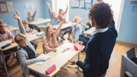 Teacher raising hand to get students' attention