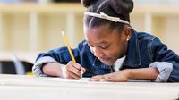 Elementary student writing at her desk