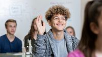 High school student raising his hand in class
