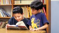Older student helps younger student in school