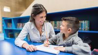 Elementary teacher works with student