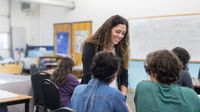 High school teacher speaks to students in classroom