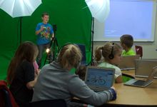 Students are working in a Multimedia class. A student is on a green screen background.