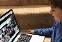 Boy participating in a video chat with his class