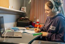 青少年在远程学习期间在她的笔记本电脑上工作