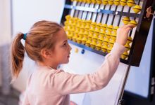 Elementary aged girl uses abacus at school