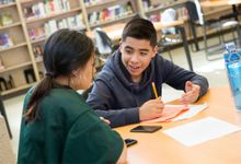 Two middle school students work on project in library at school