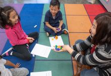 Elementary teacher works on a math assignment with children during circle time
