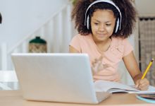 Middle school student takes notes during virtual learning session