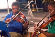 Photo of two boys playing violins
