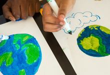 两个学生用记号笔画地球