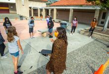 Teacher leads students in a group activity outside the school