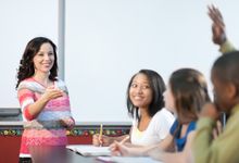 High school teacher speaking to students in classroom