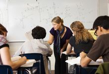 High school math teacher helps students during class