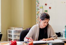 Teacher alone working at desk in classroom 